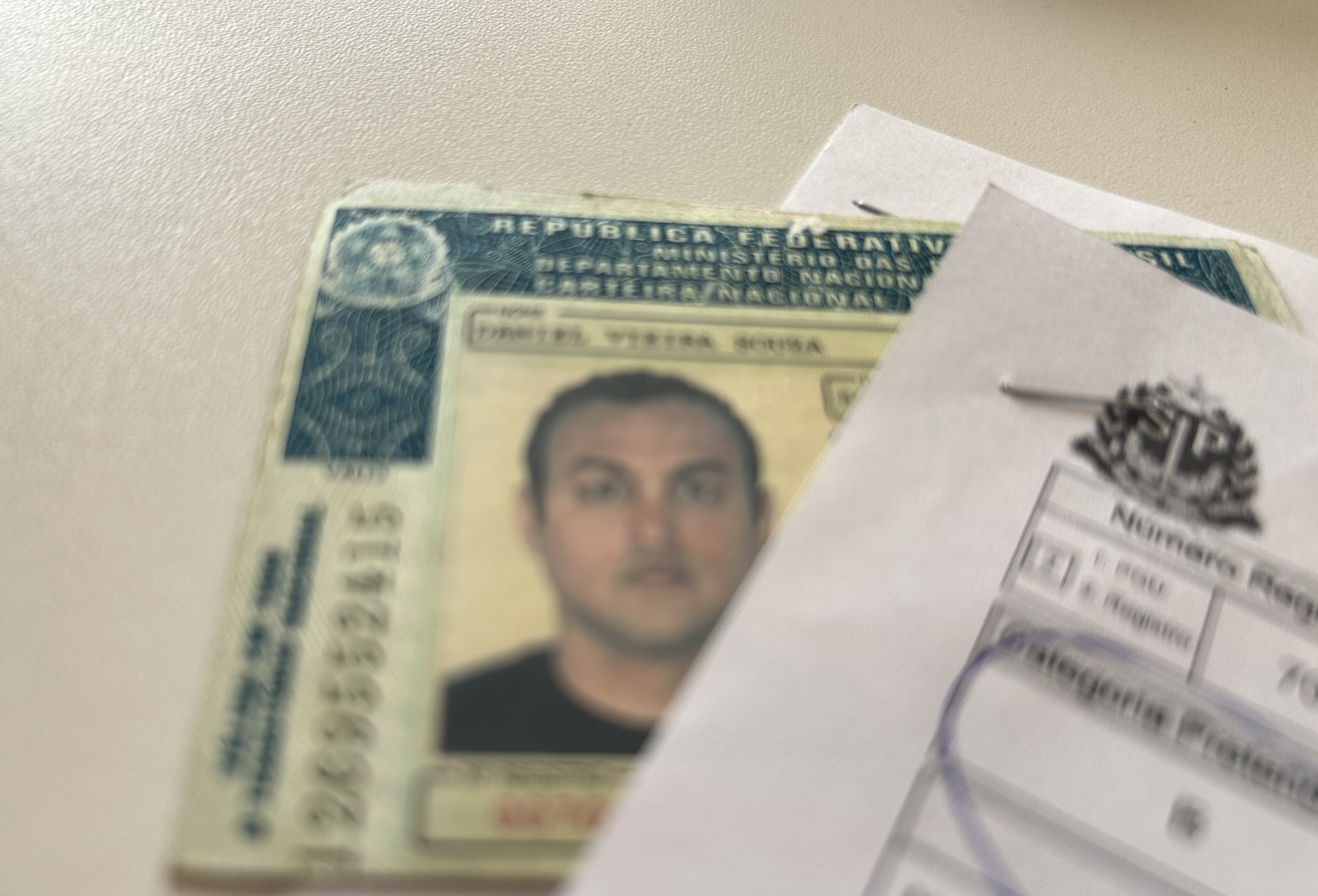 Foto da carteira de motorista antiga de Daniel e da evidência do serviço.